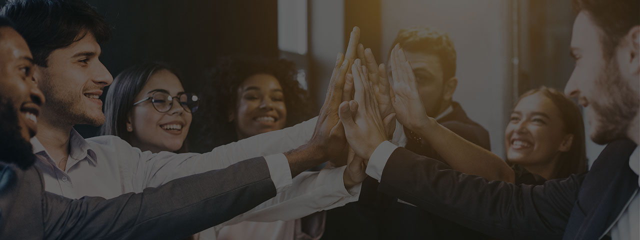 Employees placing hands together encouraging teamwork