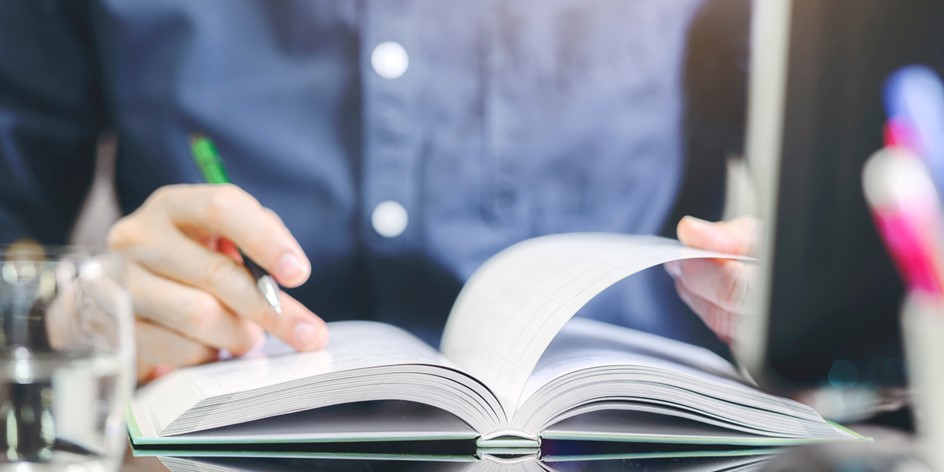 Picture for Across Our Desk column, featuring a woman reading at her desk.