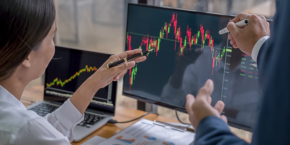 woman pointing at stock chart and discussing equity grants with colleague