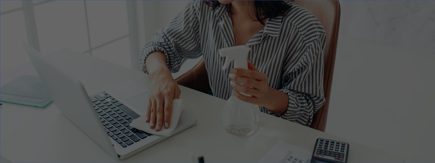 woman cleaning desk at corporate office