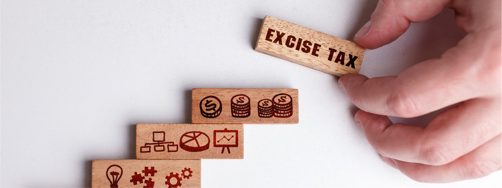 Wooden block with various financial-related images and the words "excise tax"
