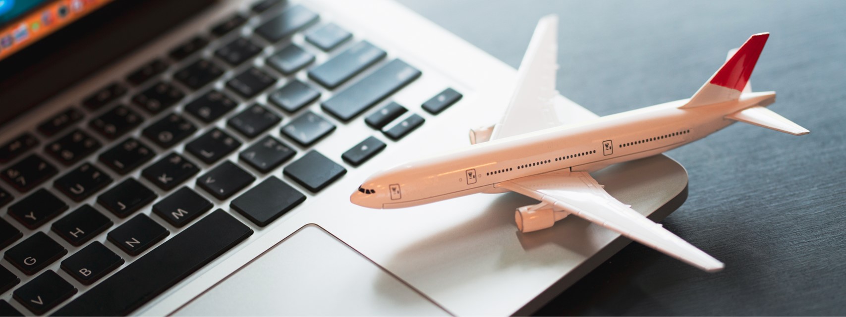 model airplane sitting on the keyboard to a laptop computer