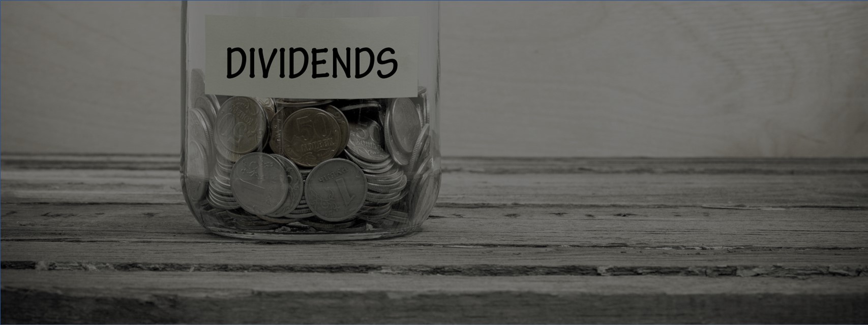 Glass jar filled with coins and labelled "Dividends"