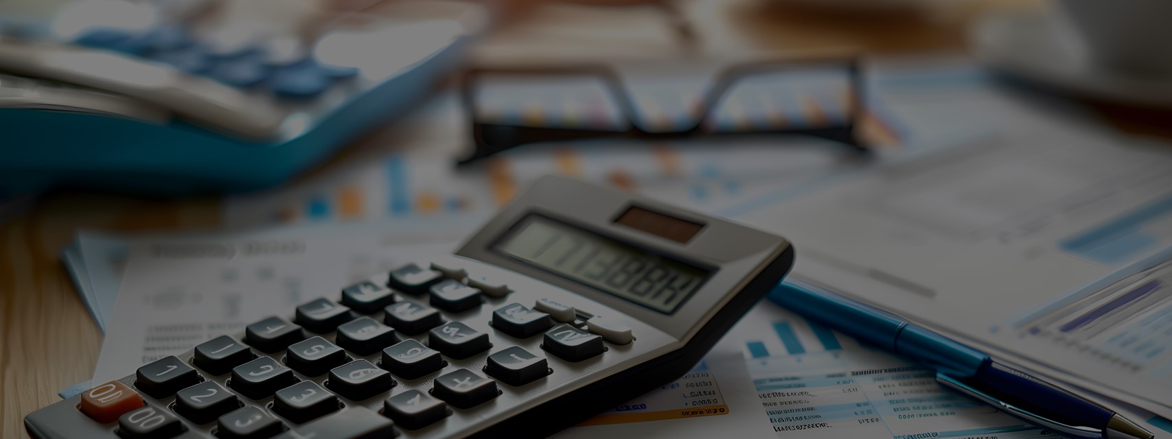 Calculator on financial statement and balance sheet on desk of CFO