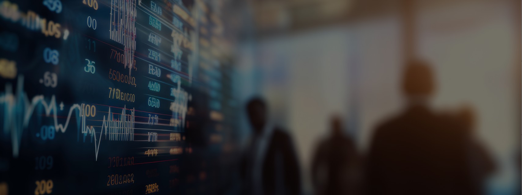 Blurred scene of corporate insiders looking at a digital stock market display