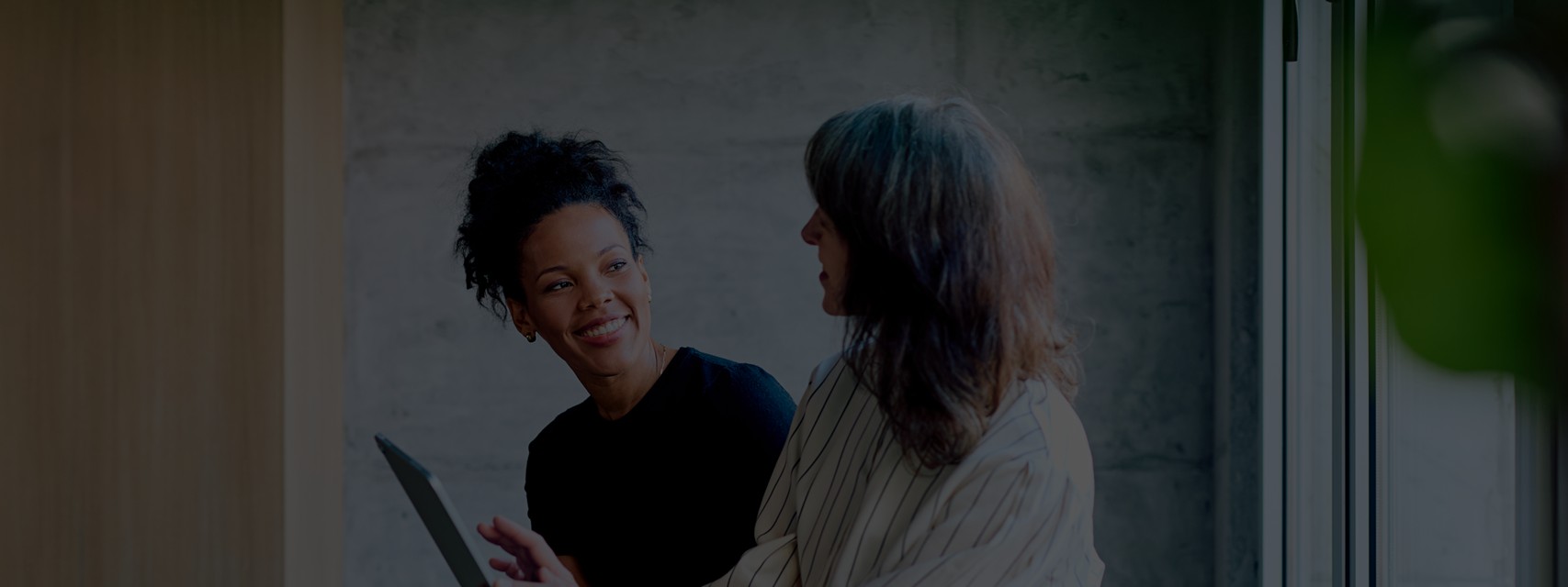Two business women fostering mentorship and connection in an office.