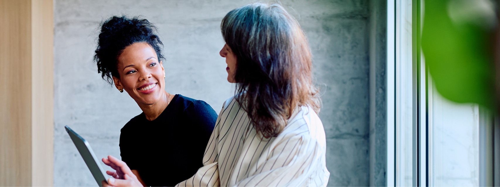 Two business women fostering mentorship and connection in an office.