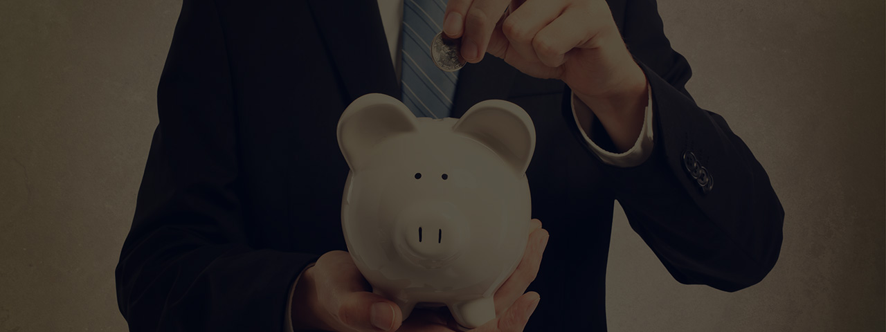 Businessman inserting coin into piggy bank