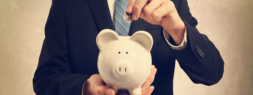 Businessman inserting coin into piggy bank