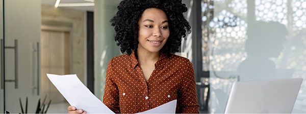 Woman reviewing paperwork and comparing to online results