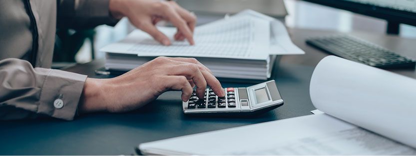 Accountant double-checking spreadsheet with a calculator
