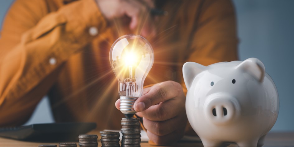 Conceptual image of wealth creation with increasing stacks of coins, piggy bank, and a light bulb