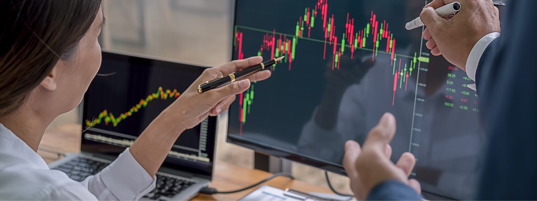 woman pointing at stock chart and discussing equity grants with colleague