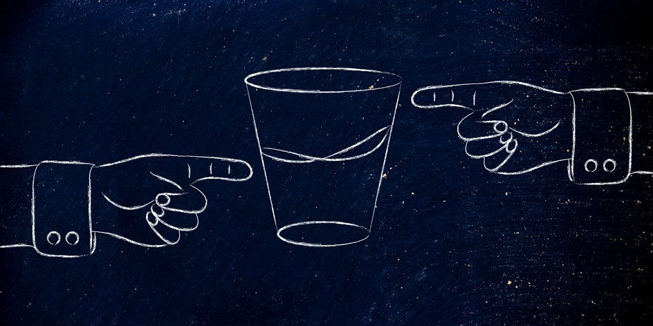 drawing of two hands pointing at the water level in a cup that is either half empty or half full