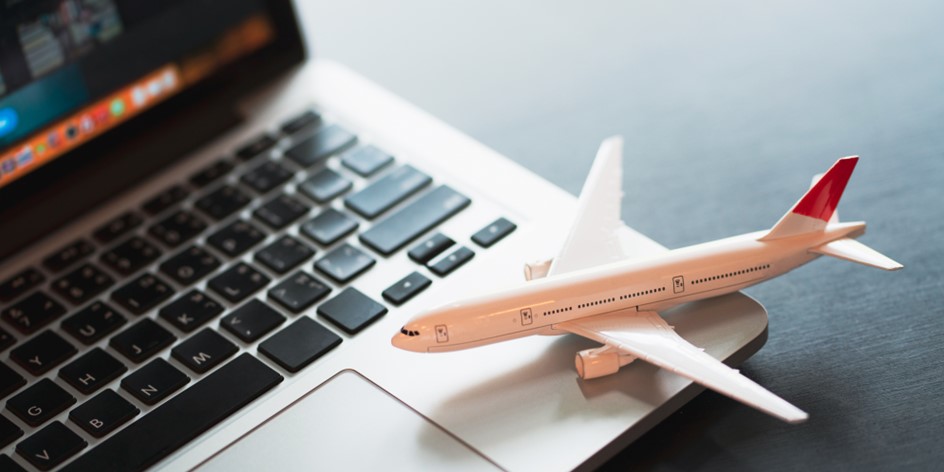 Model airplane sitting on keyboard of laptop computer