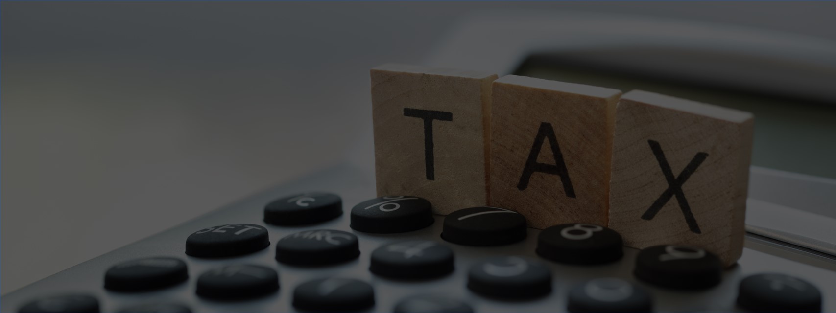 calculator with word "tax" spelled out in scrabble tiles