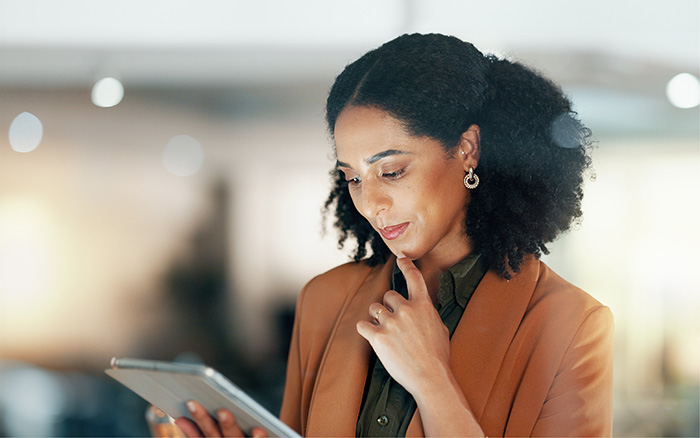 Businesswoman reviewing content on tablet Businesswoman reading content on tablet